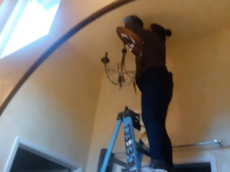 Electrician installing a chandelier in a Ottawa residence